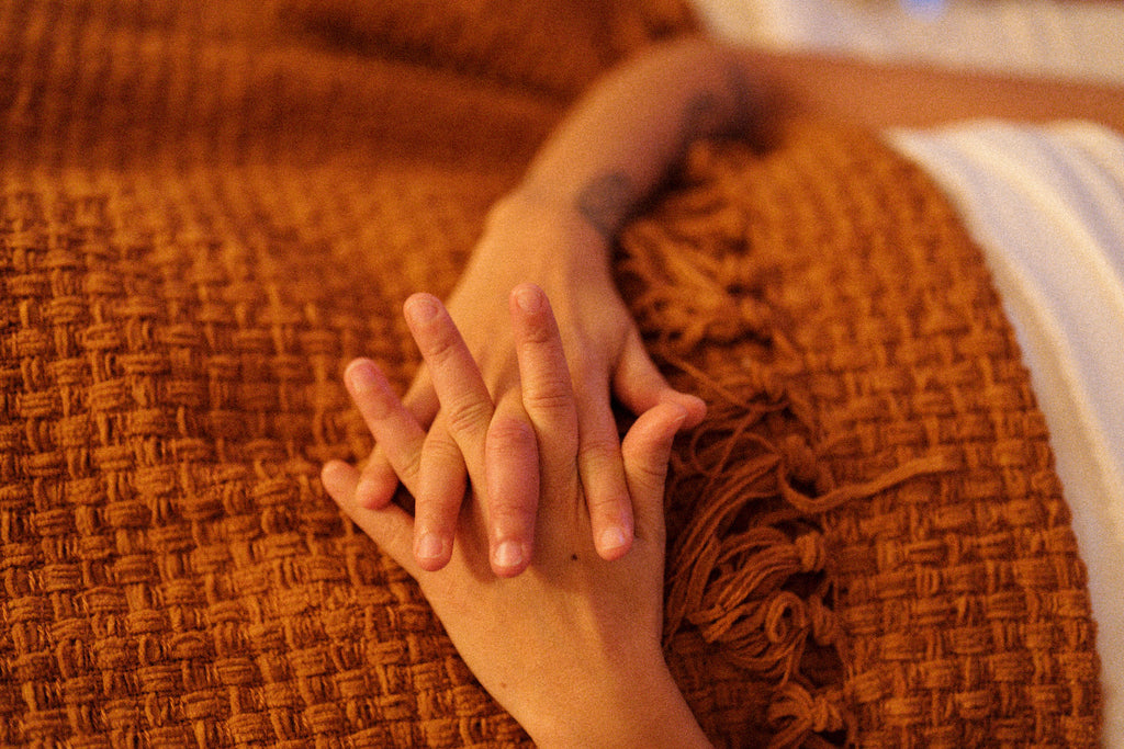 Hands are crossed on top of a terracotta blanket at Green Revolution Studio in Bethesda, MD